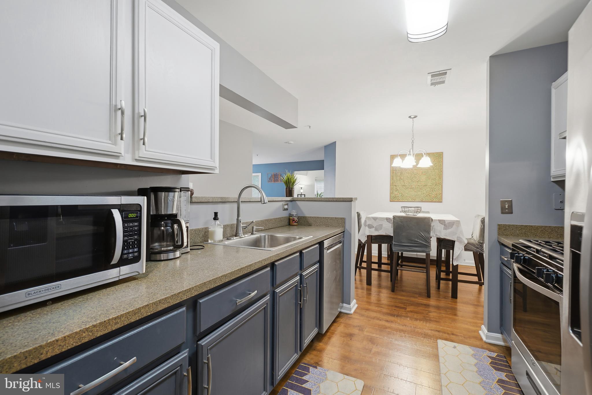 14151 Cuddy Loop, Unit 101 Woodbridge, VA 22193 - Photo 19 of 45 a kitchen with stainless steel appliances granite countertop a stove a sink and a microwave