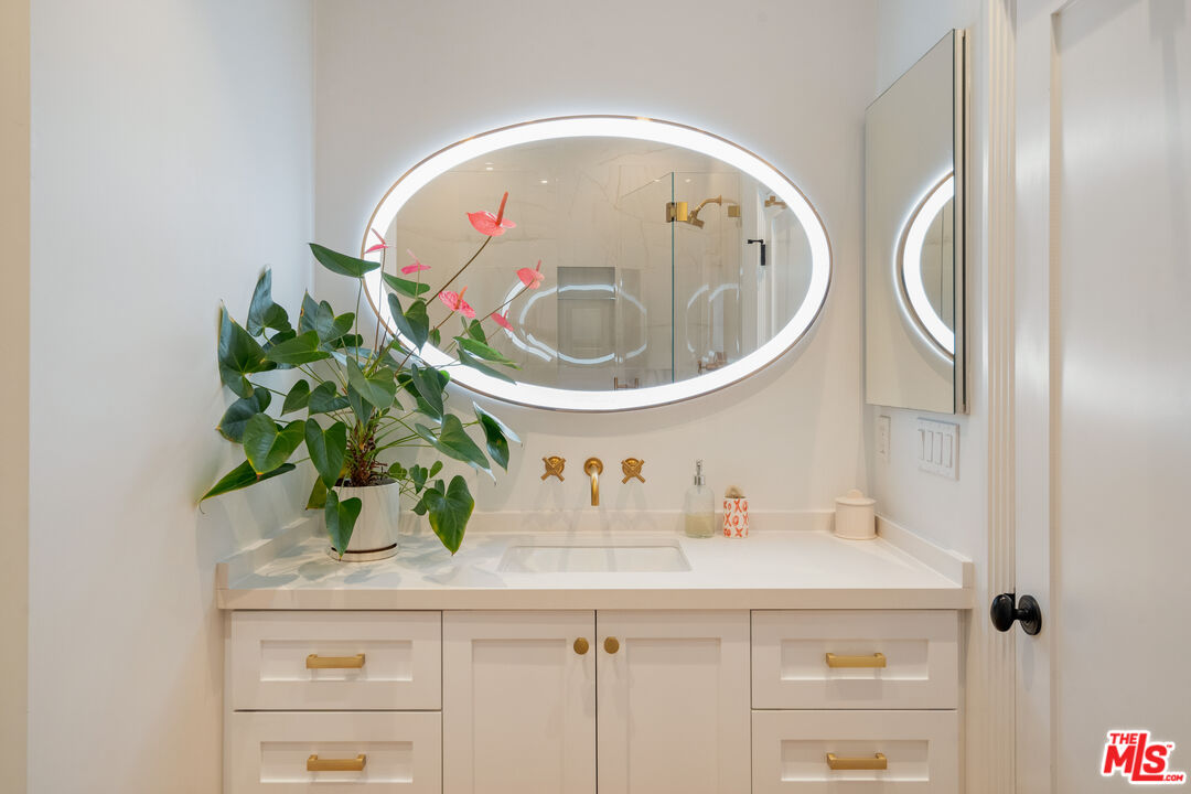 128 Roma Court Marina del Rey, CA 90292 - Photo 40 of 52 a bathroom with a sink a mirror and a potted plant