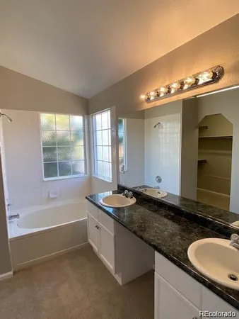 an empty room with windows and ceiling fan