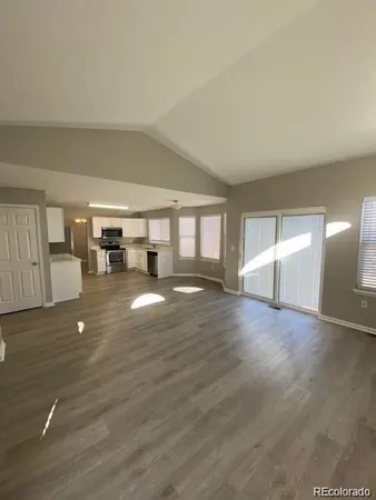 a view of empty room with wooden floor