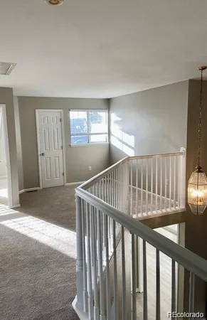 a view of staircase with railing and a rug