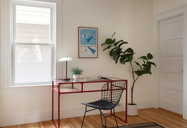 a view of a room with a window and wooden floor
