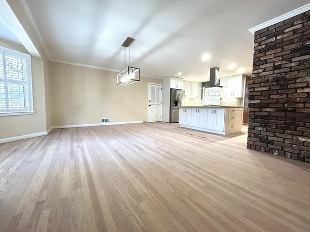 a view of a kitchen with wooden floor and a ceiling fan