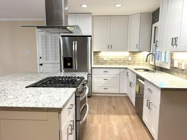 a kitchen with stainless steel appliances granite countertop a refrigerator stove and sink