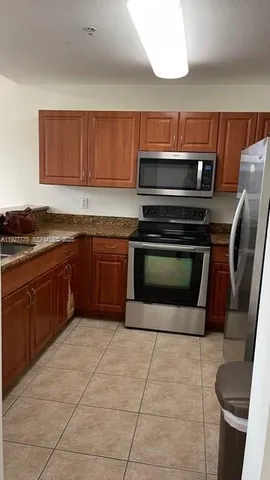 a kitchen with a stove top oven cabinets and stainless steel appliances