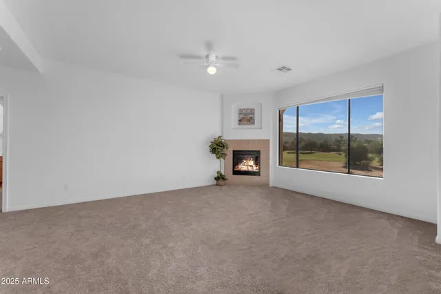 an empty room with fireplace and a window