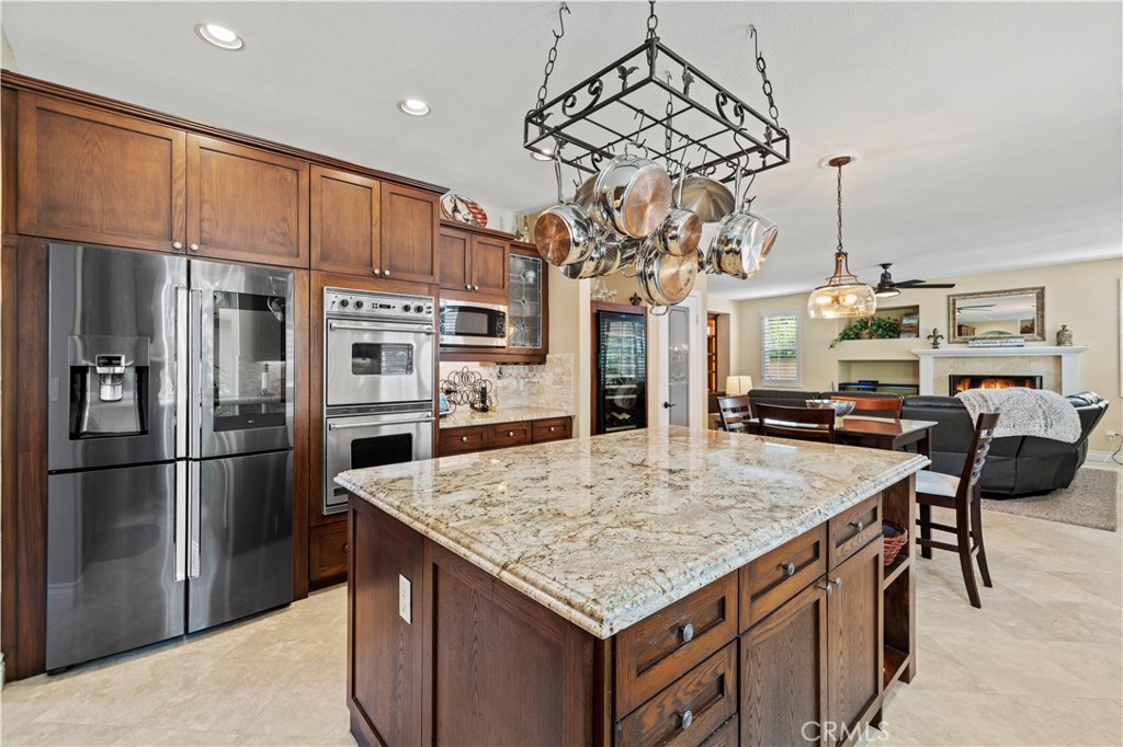 25221 Summerhill Lane Stevenson Ranch, CA 91381 - Photo 20 of 74 a kitchen with stainless steel appliances granite countertop a table chairs and refrigerator