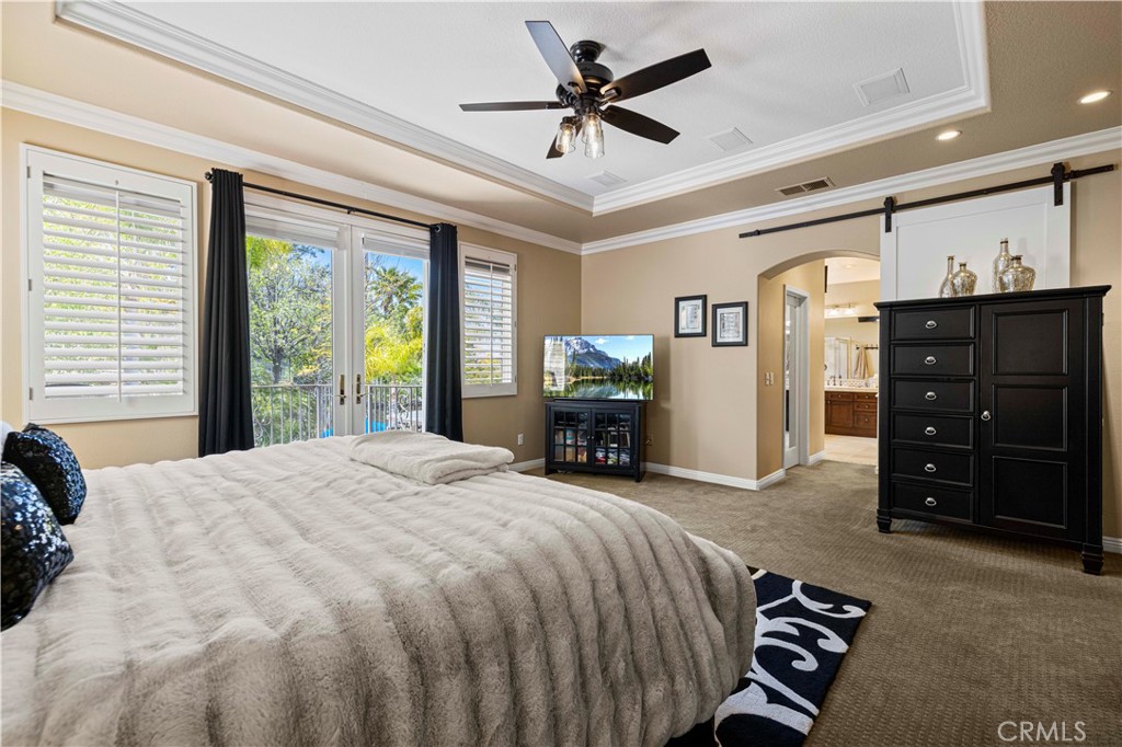 25221 Summerhill Lane Stevenson Ranch, CA 91381 - Photo 46 of 74 a spacious bedroom with a bed and a chandelier