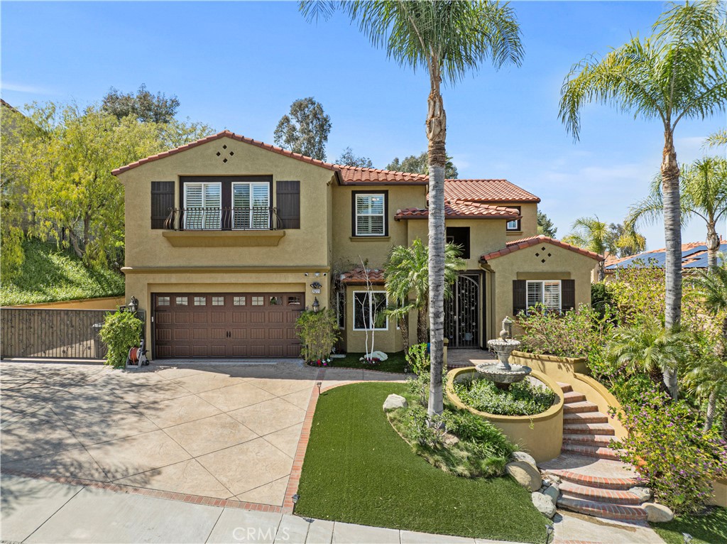 25221 Summerhill Lane Stevenson Ranch, CA 91381 - Photo 70 of 74 a front view of a house with a yard and potted plants