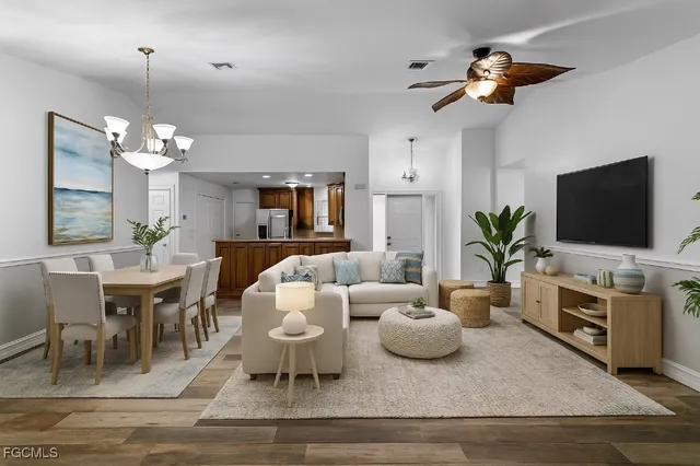 a living room with furniture a chandelier and a flat screen tv