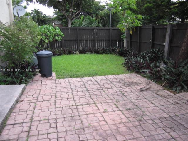 11350 Southwest 68th Terrace Miami, FL 33173 - Photo 14 of 31 a view of a backyard with plants and a bench with wooden fence
