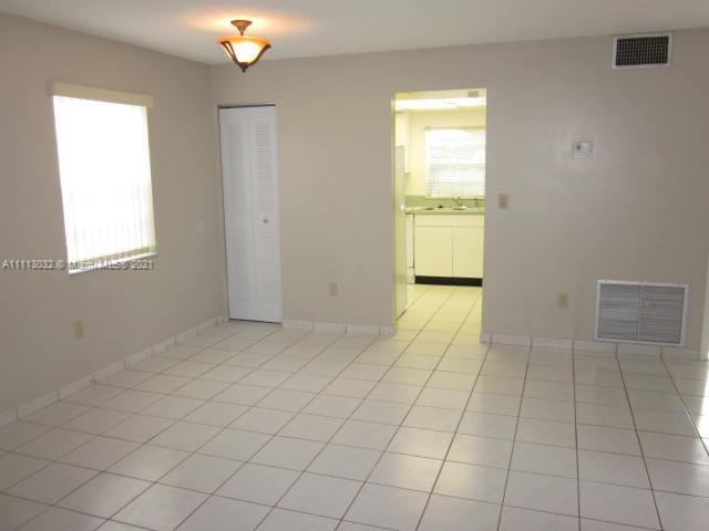 11350 Southwest 68th Terrace Miami, FL 33173 - Photo 3 of 31 an empty room with chandelier fan and windows