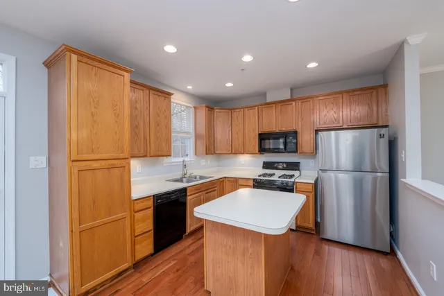 a kitchen with a refrigerator a sink and wooden cabinets