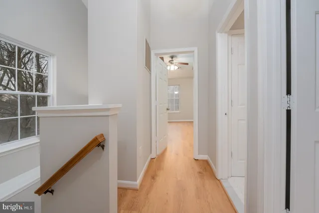 a view of a hallway with wooden floor and staircase