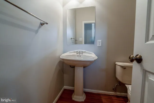 a bathroom with a sink a toilet and a mirror