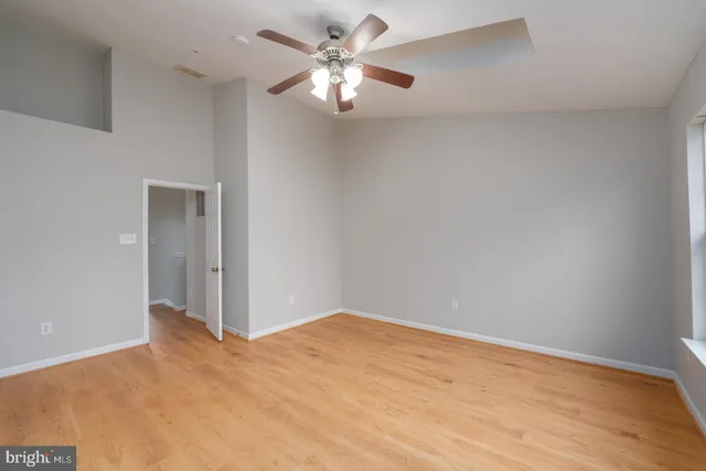 a view of a big room with wooden floor and a chandelier fan