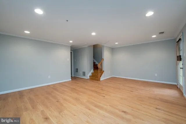 a view of empty room with wooden floor