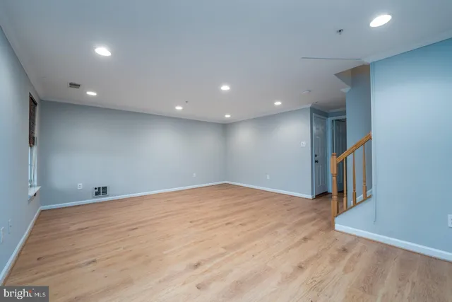 a view of an empty room with wooden floor