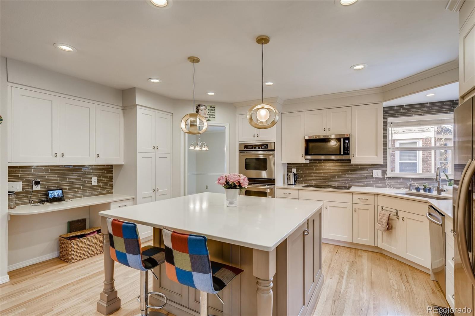 9396 Desert Willow Road Highlands Ranch, CO 80129 - Photo 7 of 40 a kitchen with stainless steel appliances a stove sink microwave and cabinets