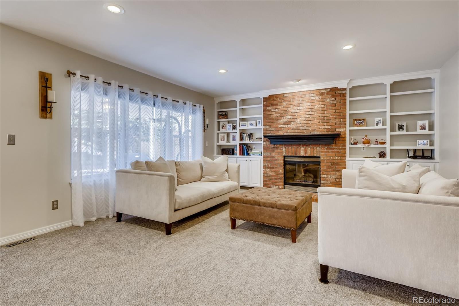 9396 Desert Willow Road Highlands Ranch, CO 80129 - Photo 10 of 40 a living room with furniture a fireplace and a flat screen tv