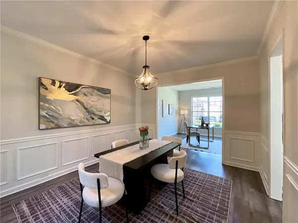 a dining room with furniture wooden floor a rug and a chandelier