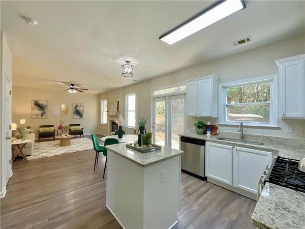 a large kitchen with a counter top space a sink stainless steel appliances and cabinets
