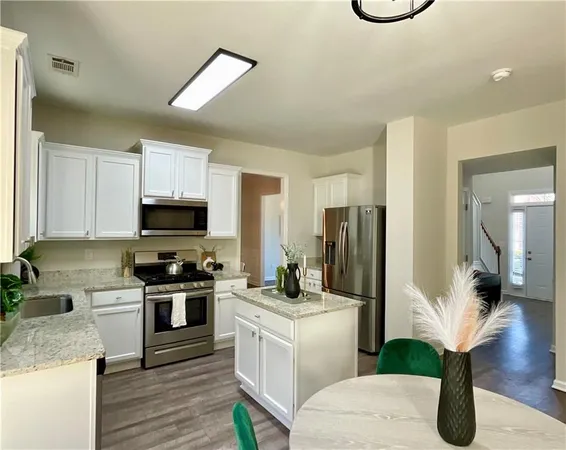 a kitchen with white cabinets and stainless steel appliances