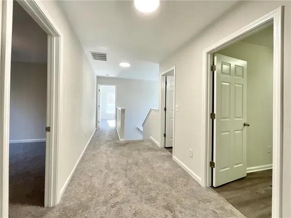 a view of a hallway with a room and a bathroom