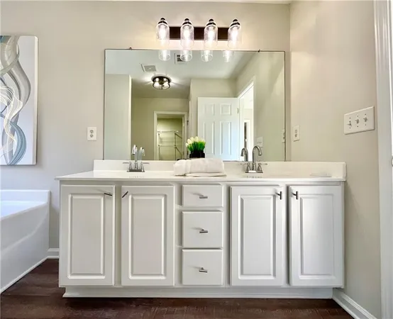 a bathroom with a double vanity sink mirror and bathtub