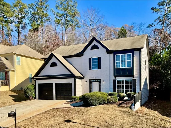 a front view of a house with a yard and potted plants