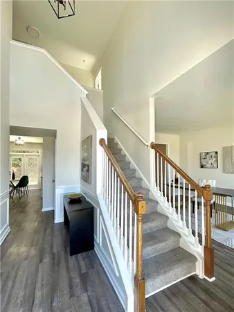 a view of a hallway with wooden floor and staircase