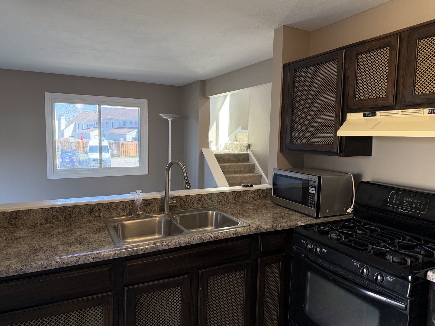 7594 Sarson Way Hanover Park, IL 60133 - Photo 9 of 26 a kitchen with granite countertop a sink a stove and cabinets