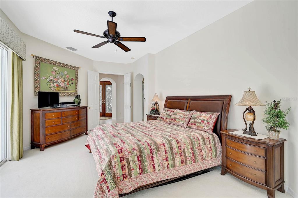 2111 Muskogee Trail Nokomis, FL 34275 - Photo 12 of 58 a bedroom with a large bed and a chandelier