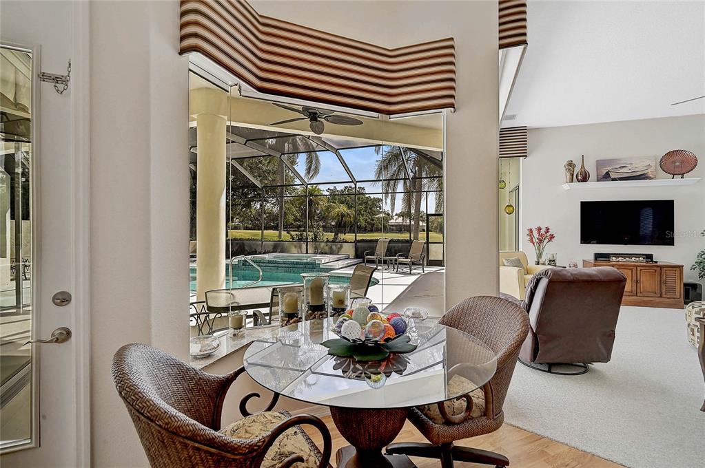 2111 Muskogee Trail Nokomis, FL 34275 - Photo 24 of 58 a dining room with furniture a rug and a floor to ceiling window