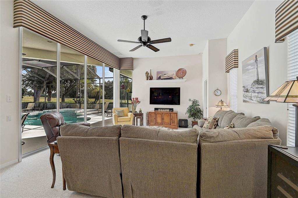 2111 Muskogee Trail Nokomis, FL 34275 - Photo 30 of 58 a living room with furniture a flat screen tv and a large window