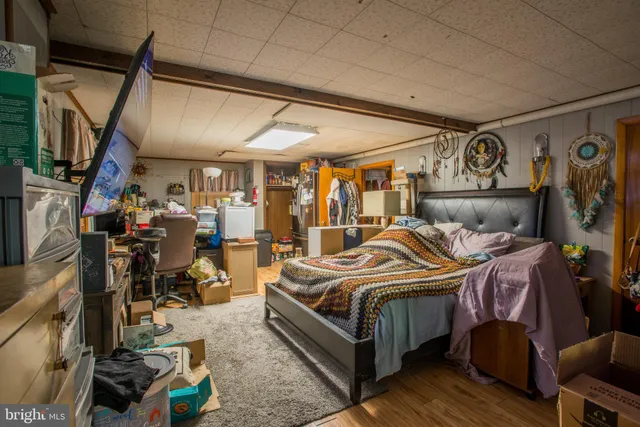 a bedroom with bed and wooden floor