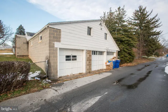 a view of a white house with a yard and garage