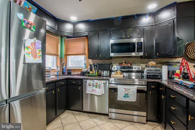 a kitchen with stainless steel appliances granite countertop a refrigerator and a stove top oven
