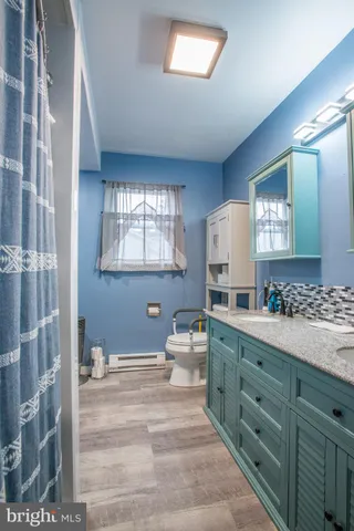 a spacious bathroom with a granite countertop sink and a mirror