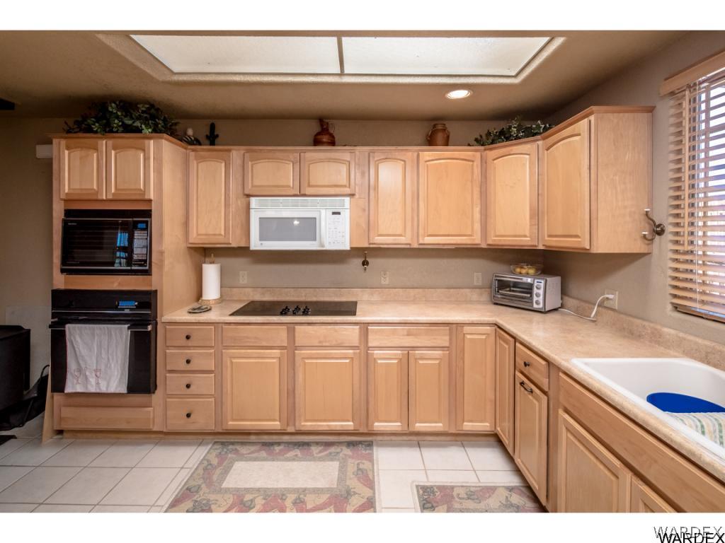 14760 Powerline Road Kingman, AZ 86401 - Photo 24 of 36 a kitchen with stainless steel appliances granite countertop a stove a sink and a microwave