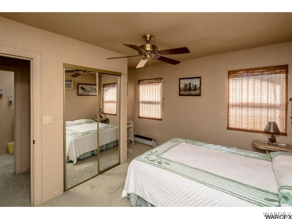 14760 Powerline Road Kingman, AZ 86401 - Photo 27 of 36 a bedroom with a bed and a chandelier