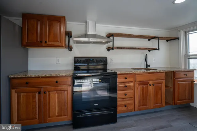 a kitchen with stainless steel appliances granite countertop a stove and a microwave oven
