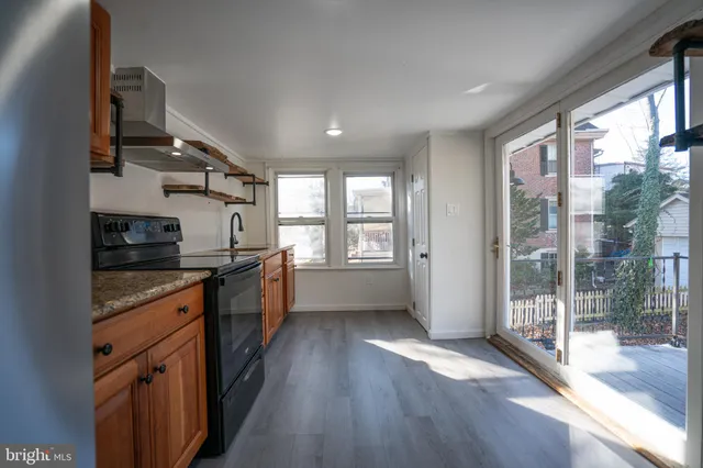 a kitchen with stainless steel appliances granite countertop a stove a sink and wooden floors