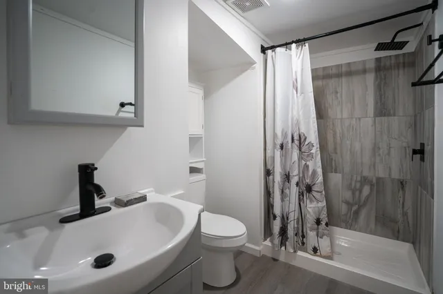 a bathroom with a sink a toilet and a shower