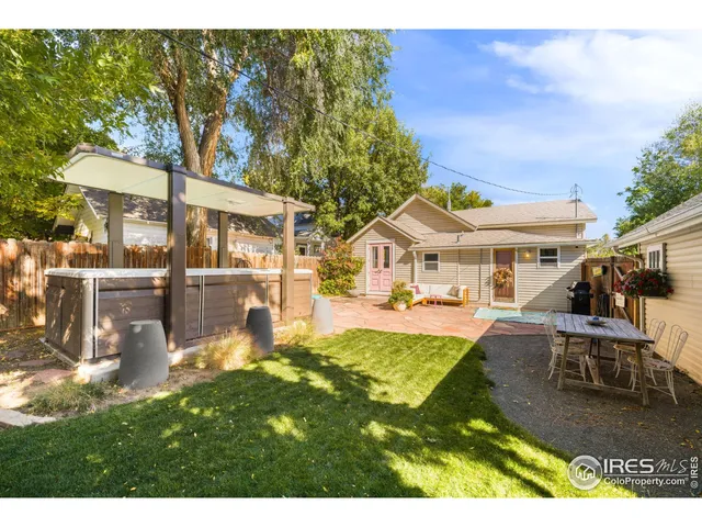 a backyard of a house with barbeque oven table and chairs