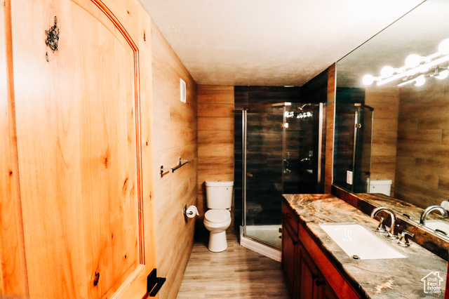 985 Russell Road Hatch, UT 84735 - Photo 21 of 30 Bathroom featuring vanity, a stall shower, wooden walls, and light wood-style flooring