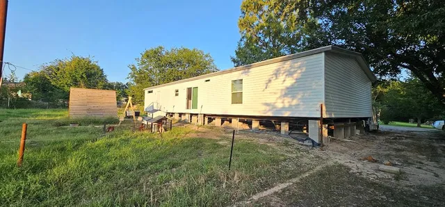 a view of a house with backyard and sitting area