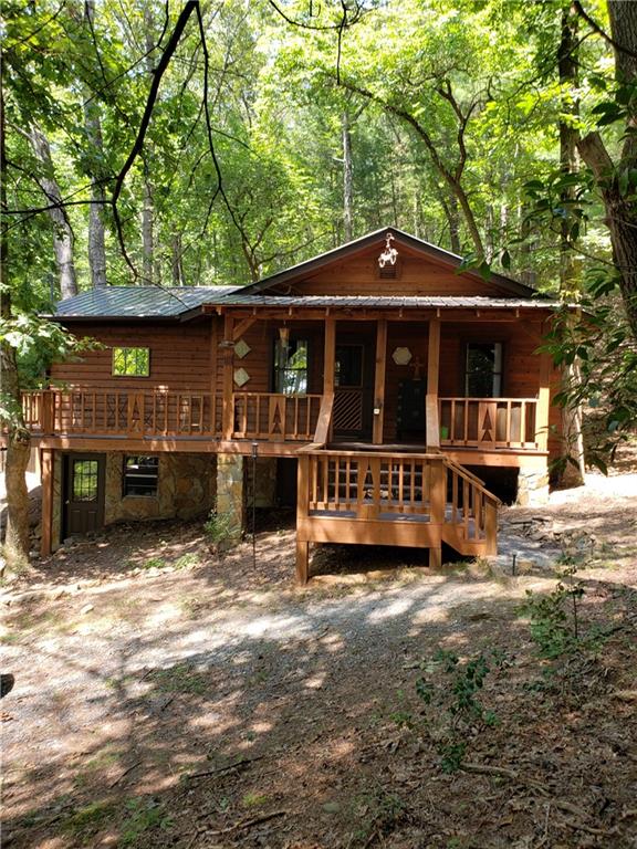 a view of a house with a yard tree and wooden fence