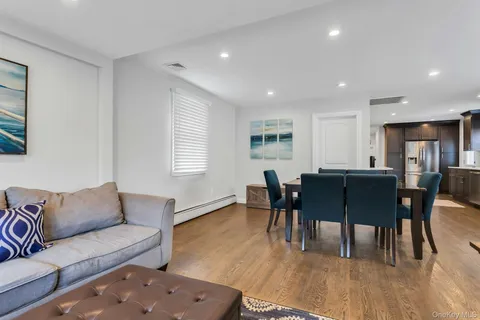 a living room with furniture a dining table and a wooden floor