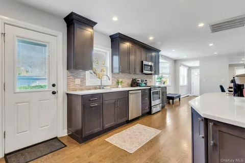 a large kitchen with kitchen island a sink stainless steel appliances and cabinets